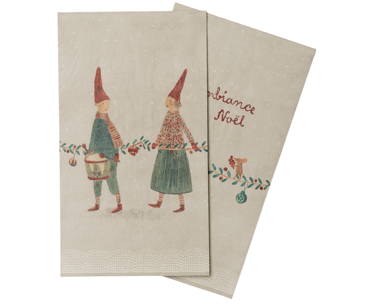 Two images of Maileg vintage-style Christmas napkin on a neutral background. One side shows two illustrated gnome figures with red pointed hats and green clothing, and the other shows the words red script with a small decorative illustration.