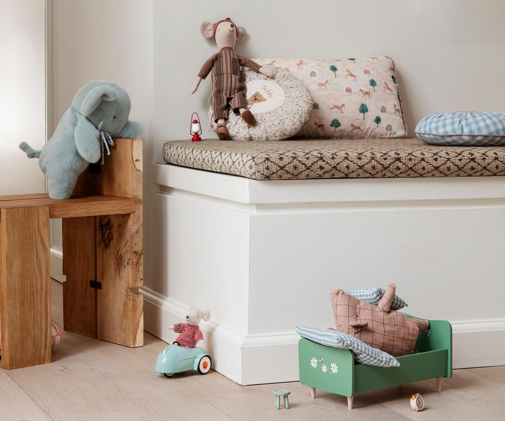 Maileg mini truffle pig displayed in a cozy nursery with soft toys and children's decor
