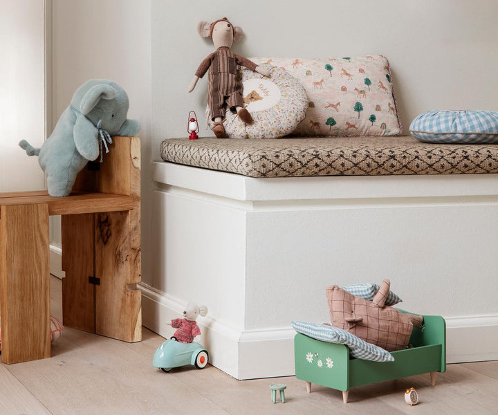 Maileg mini truffle pig displayed in a cozy nursery with soft toys and children&