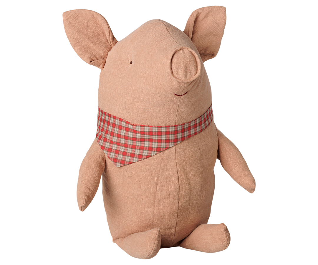 Maileg big truffle pig plush toy in powder pink with a red checked scarf, floppy ears, and a curly tail. 